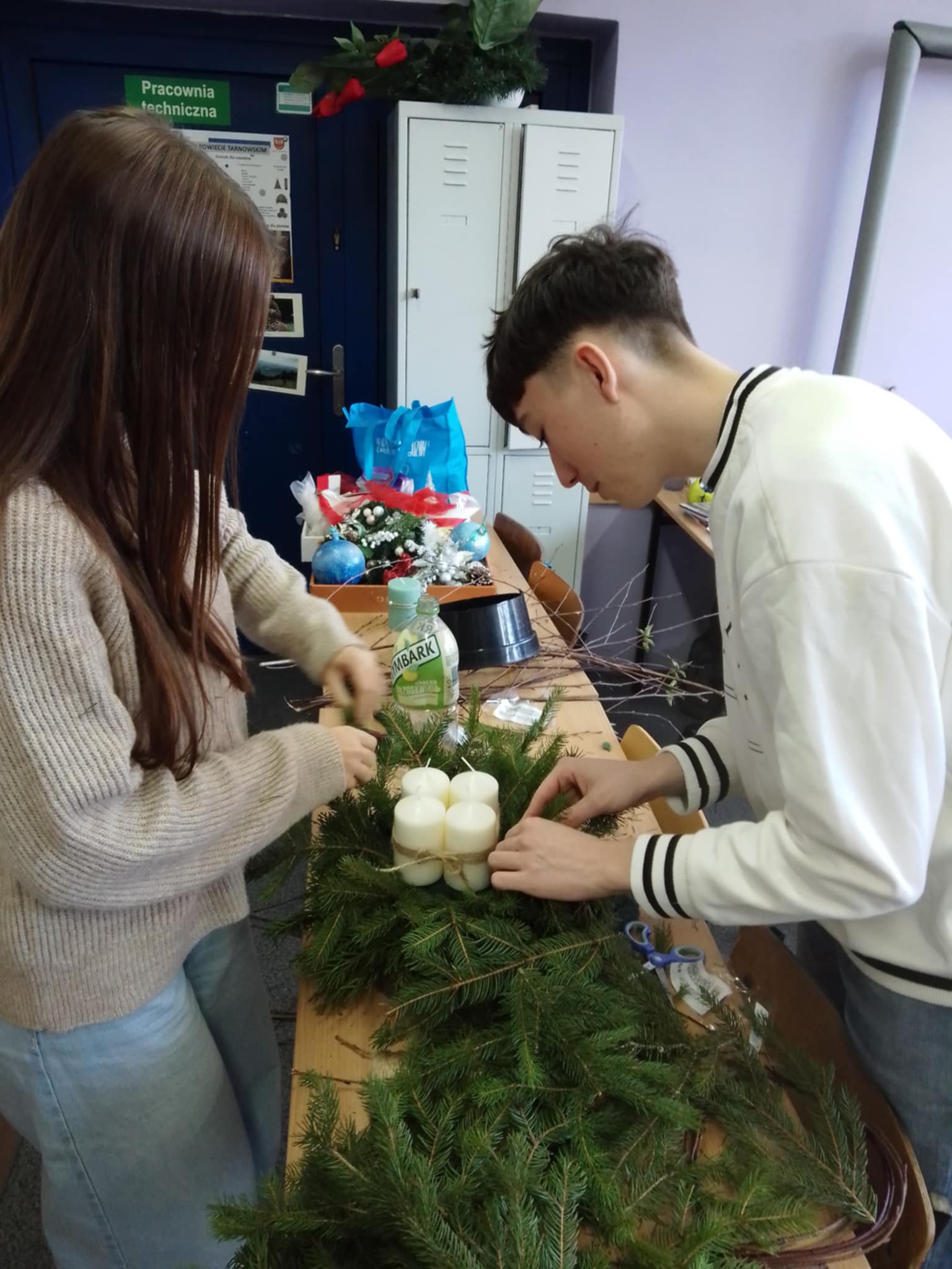 Uczniowie podczas wypelniania wieńca igliwiem