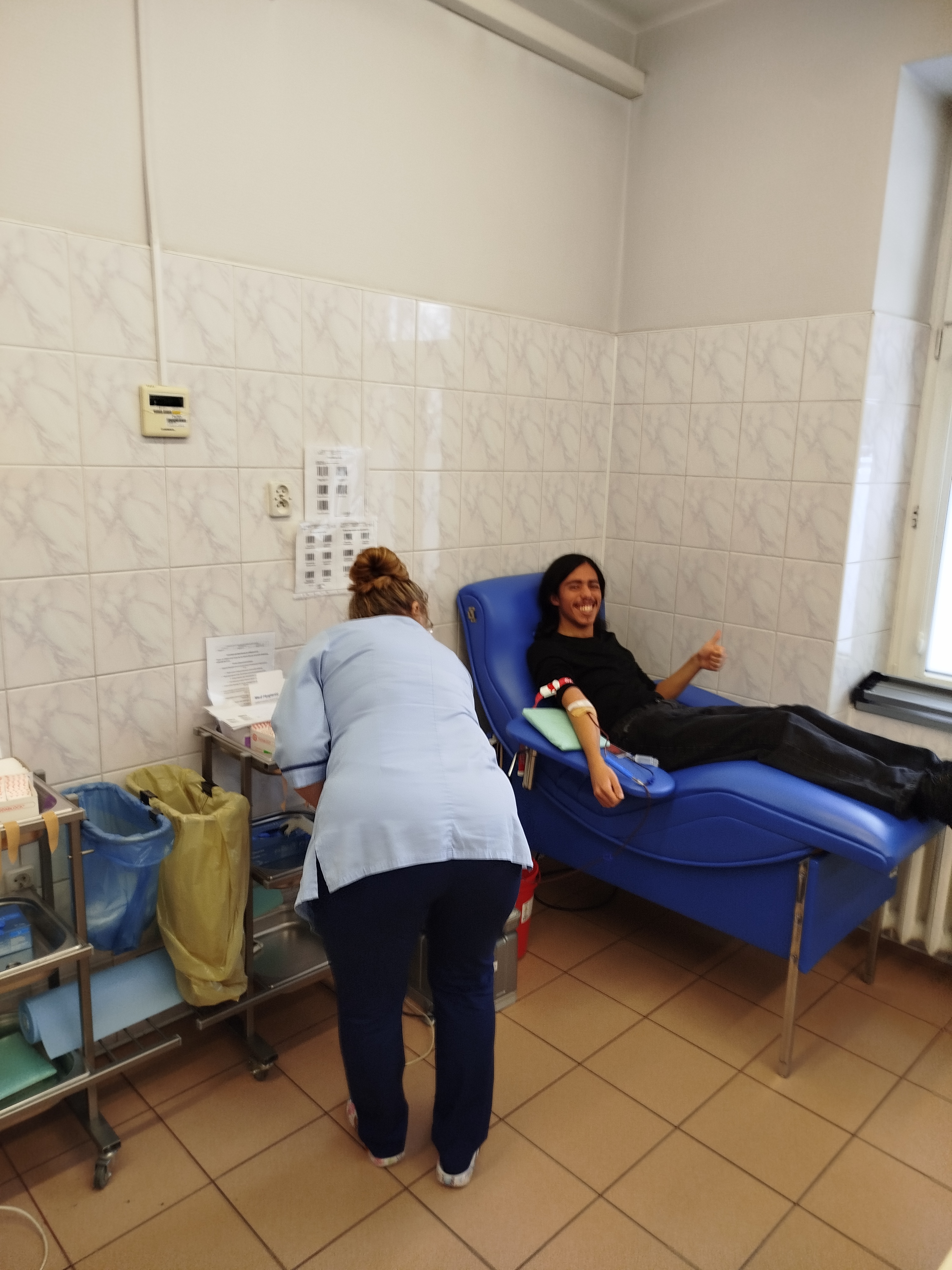 Zadowolony uczen oddajacy krew wraz z pielegniarka