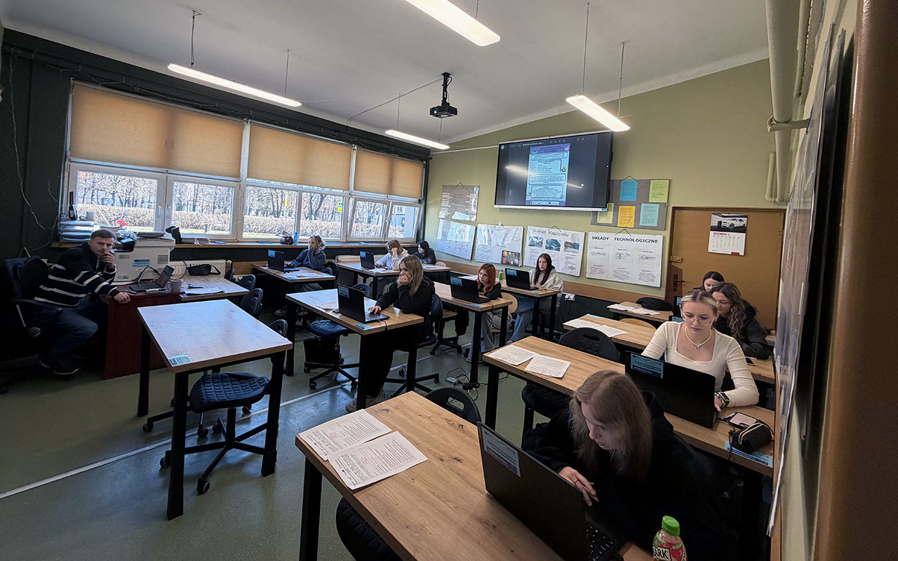 Zajecia w klasie kilku yuczniow przy laptopach