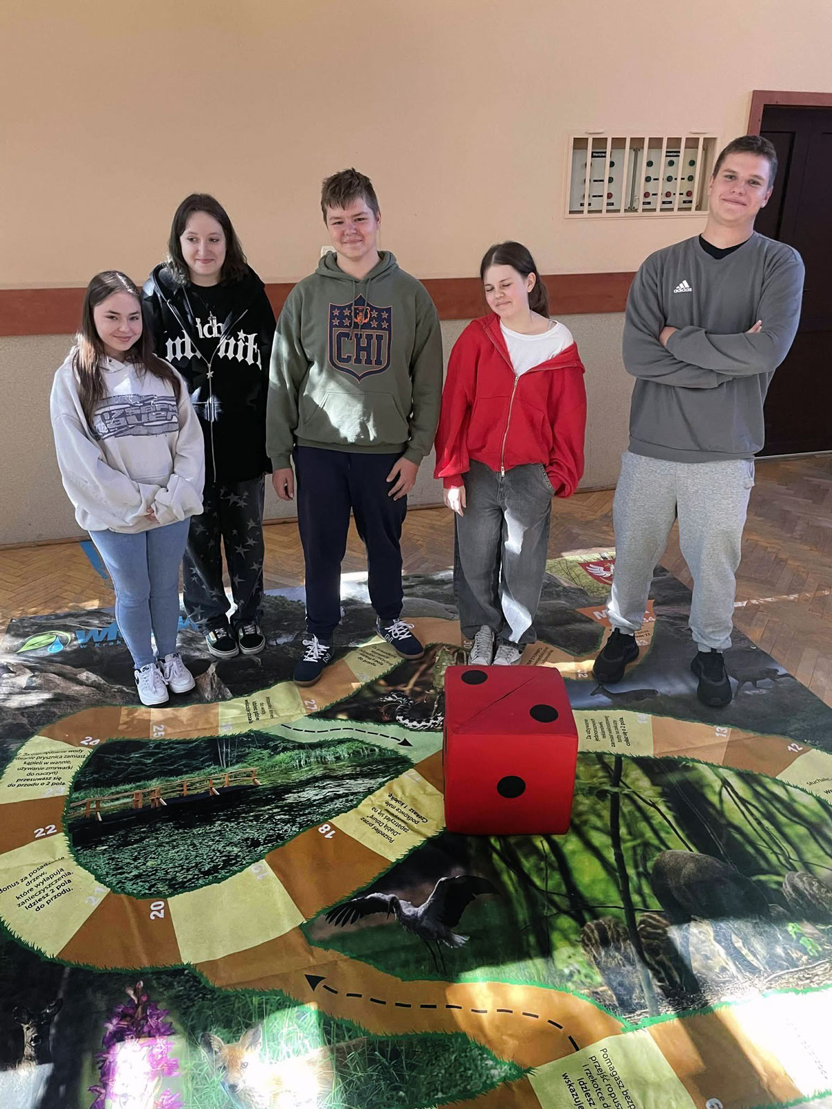 Uczniowie biorący udział w konkursie gry planszowej wielkoformatowej.