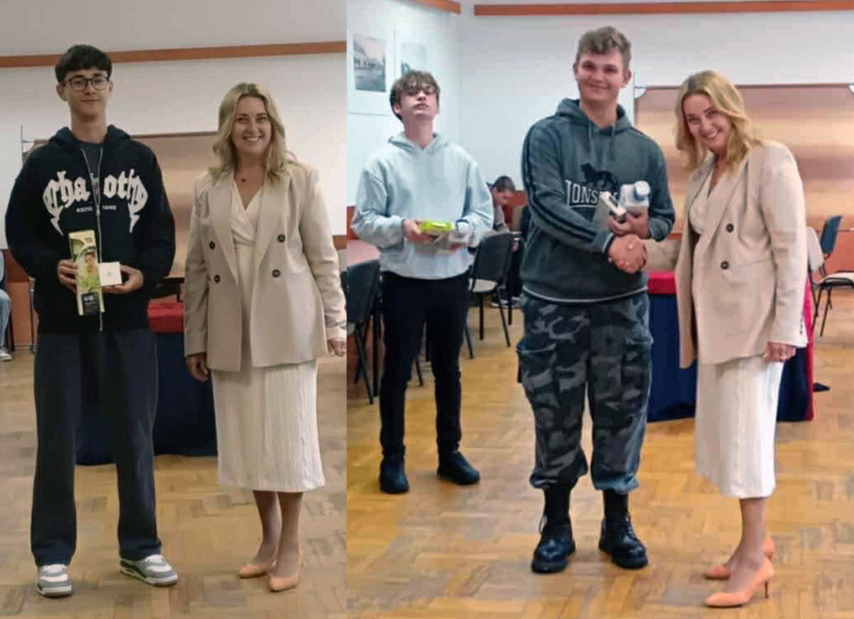 Dyrektor szkoły wręcza nagrody uczestnikom konkursu wiedzy ekologiczno-przyrodniczej. Uczniowie stoją obok siebie, odbierając dyplomy i upominki. W tle widoczna jest tablica z nazwą konkursu oraz elementami dekoracyjnymi nawiązującymi do tematyki ekologicznej.