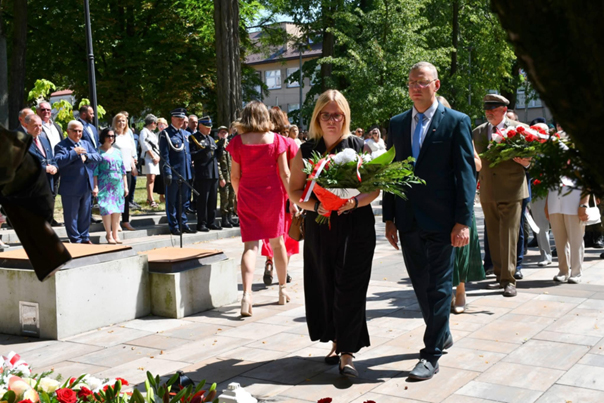 Uczestnicy uroczystasci skladaja kwiaty pod pomnikiem zolnierzy